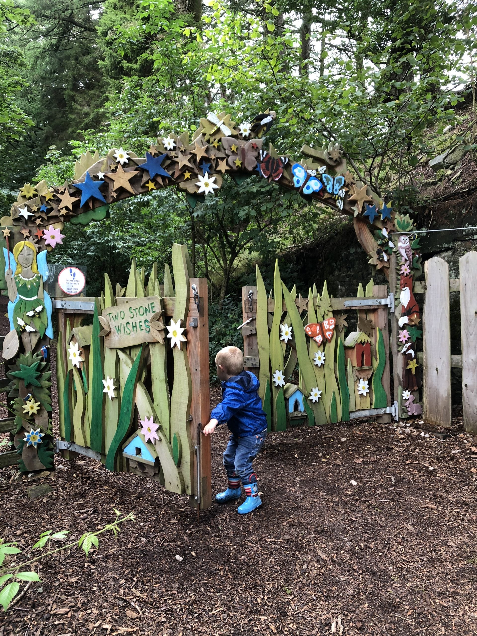 Child opening fairy-themed gate at Studfold Trail