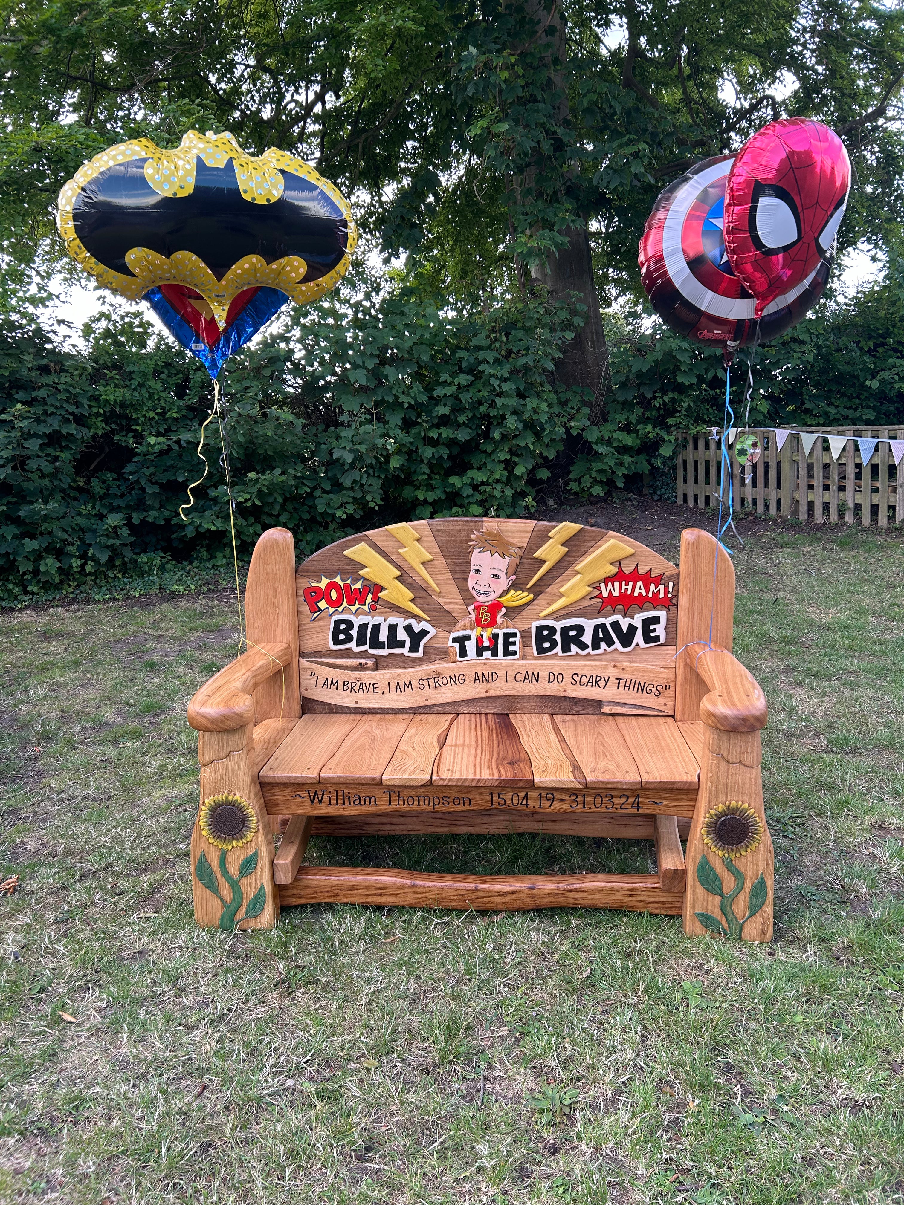 Memorial bench with balloons in a garden setting