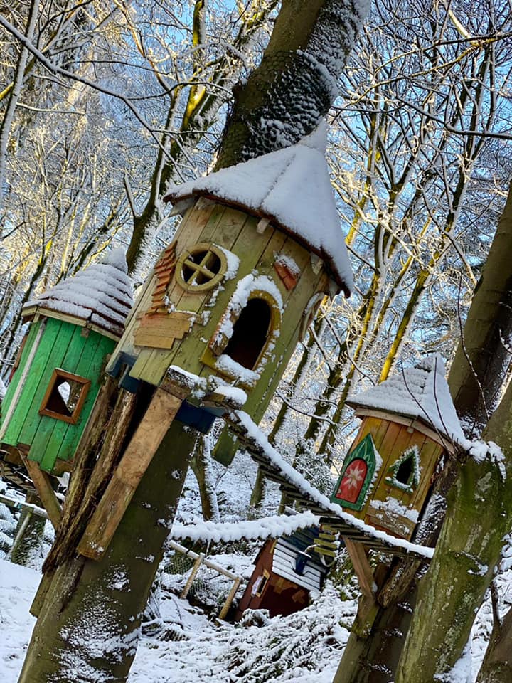 Snow-covered fairy tree houses in a winter forest