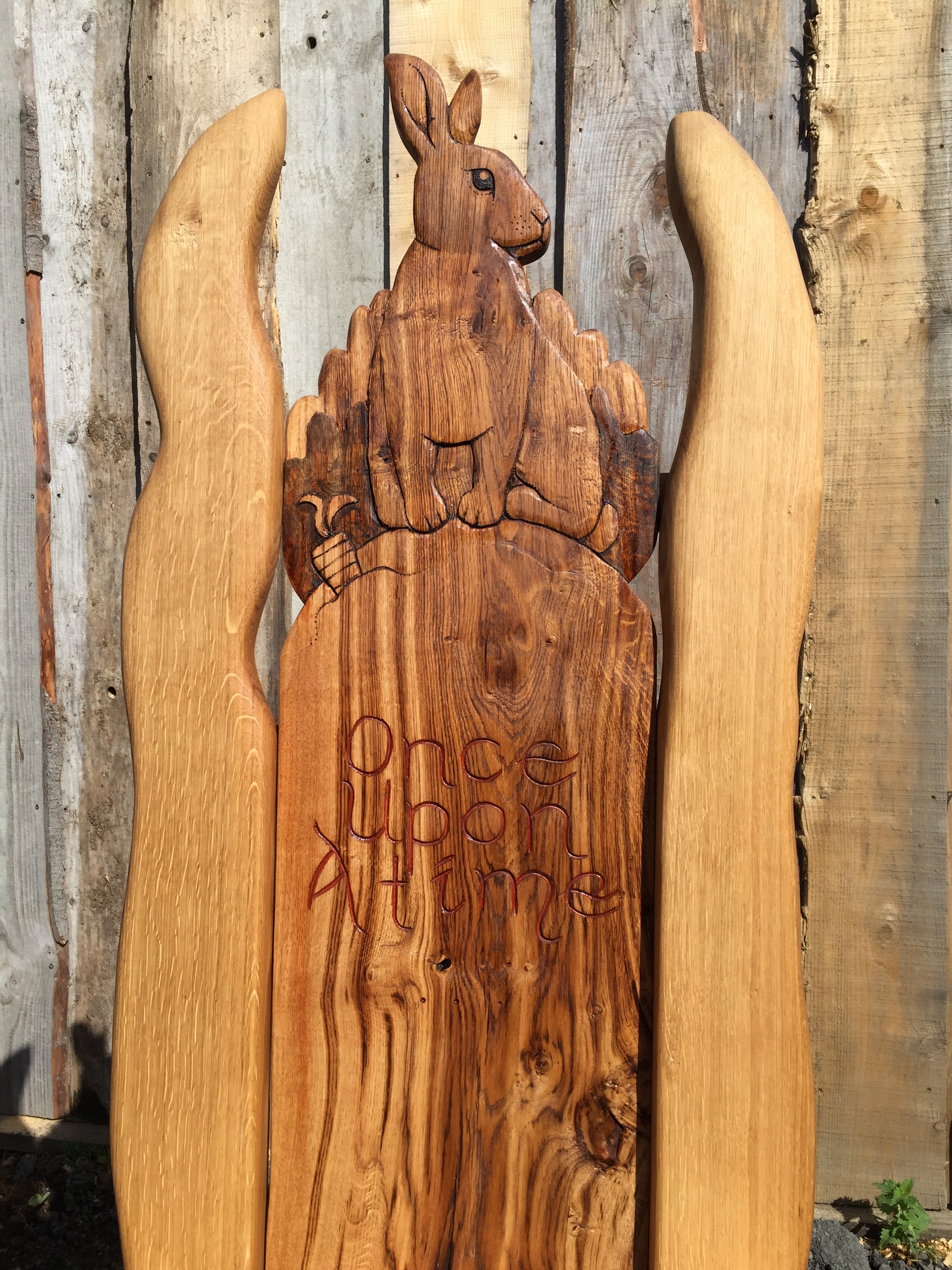 Close-up of rabbit carving with 'Once Upon A Time' inscription.