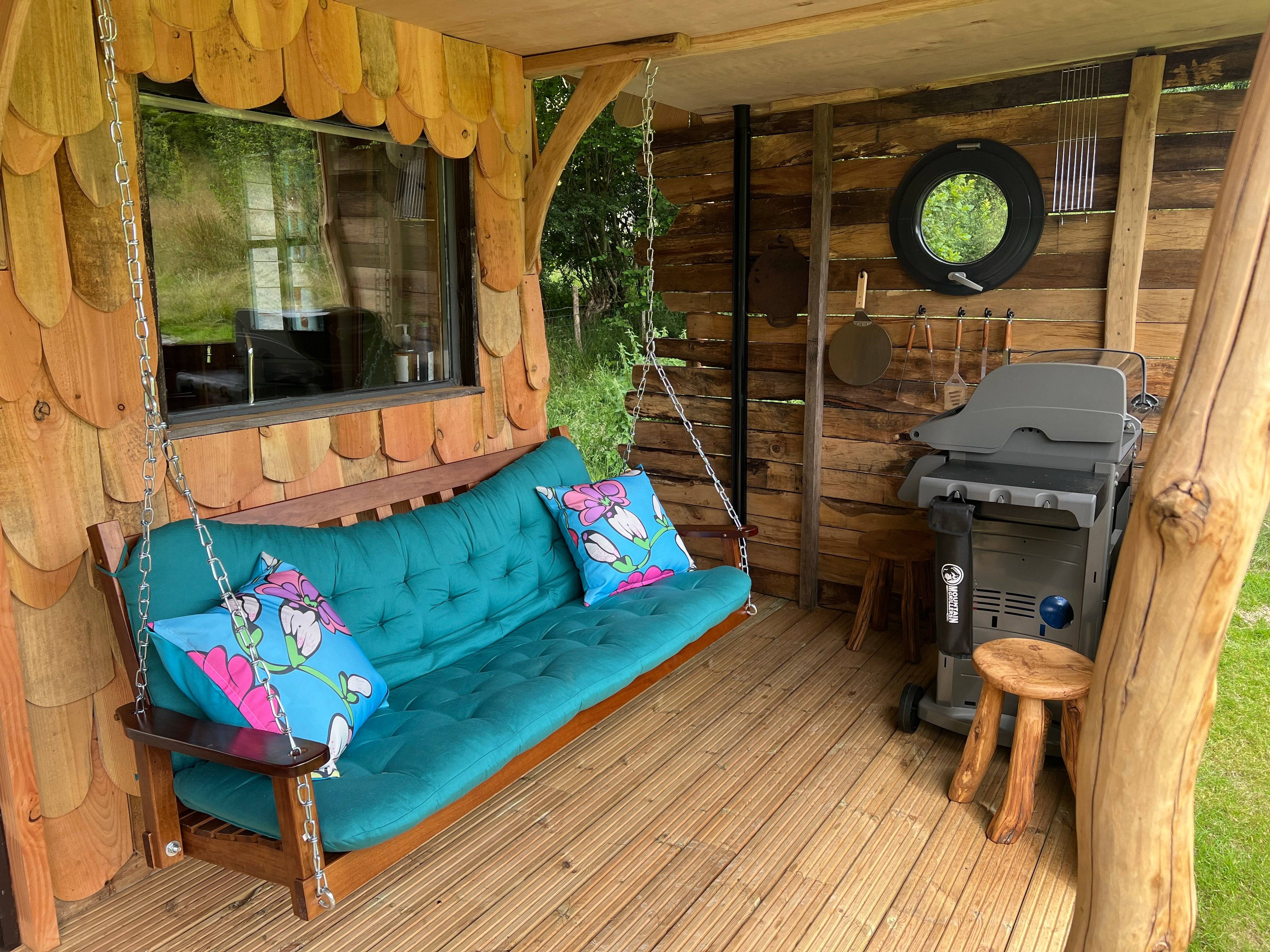 Porch of shepherd's hut with swing and grill