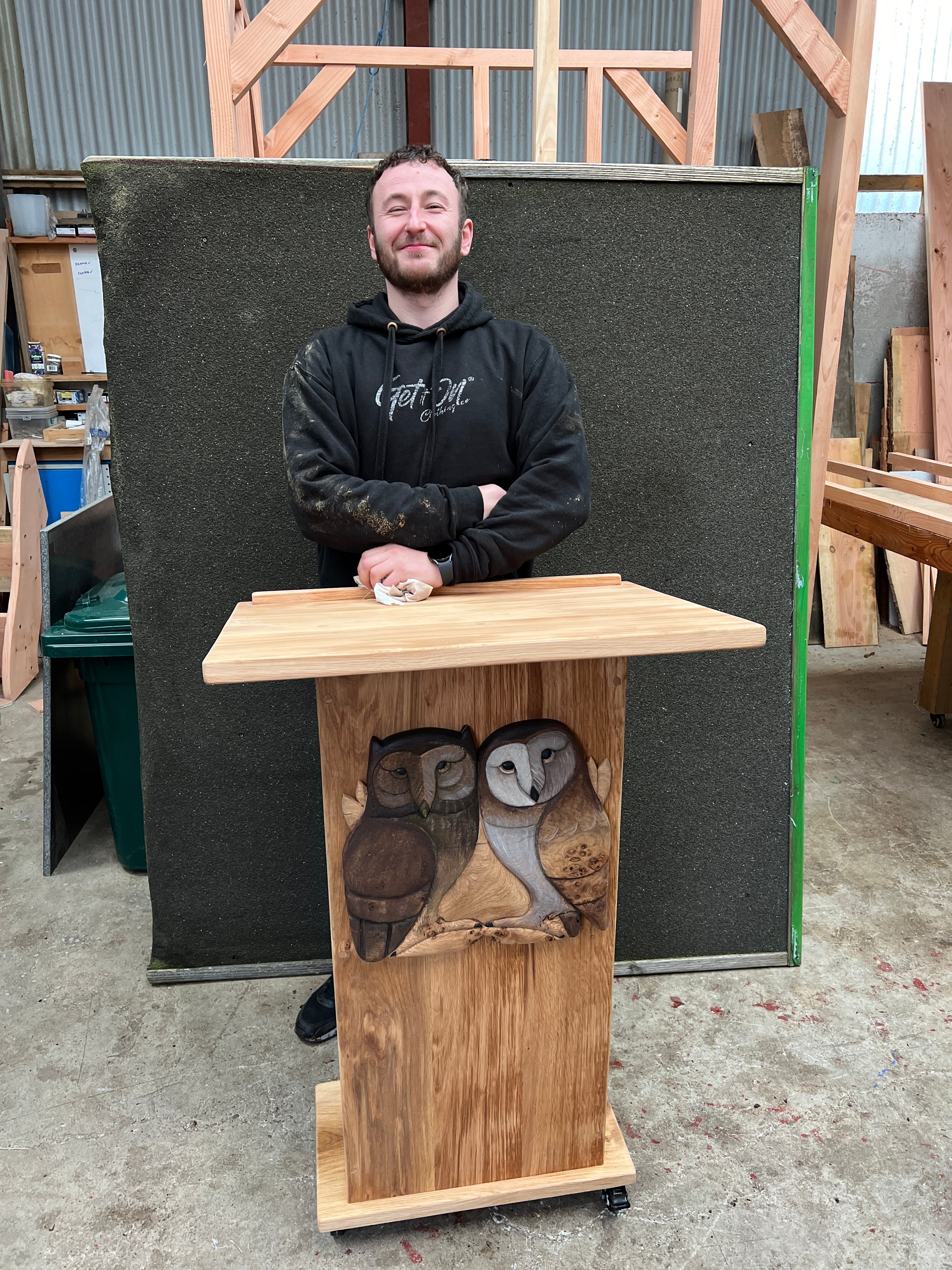 Artisan standing with bespoke owl-themed lectern