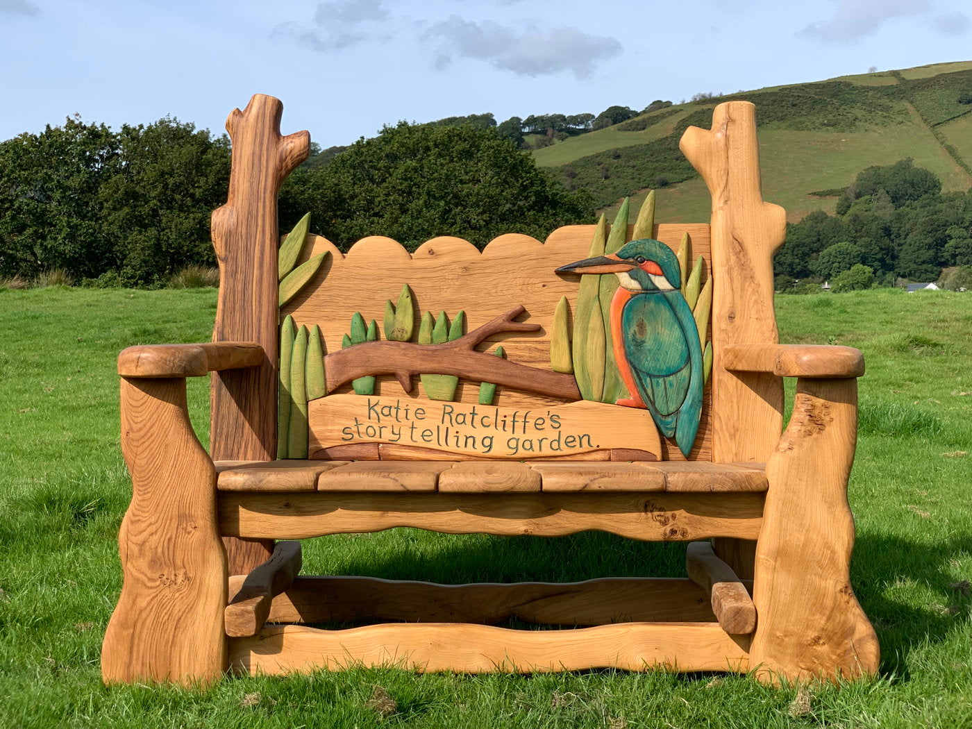 Storytelling garden bench with kingfisher carving.