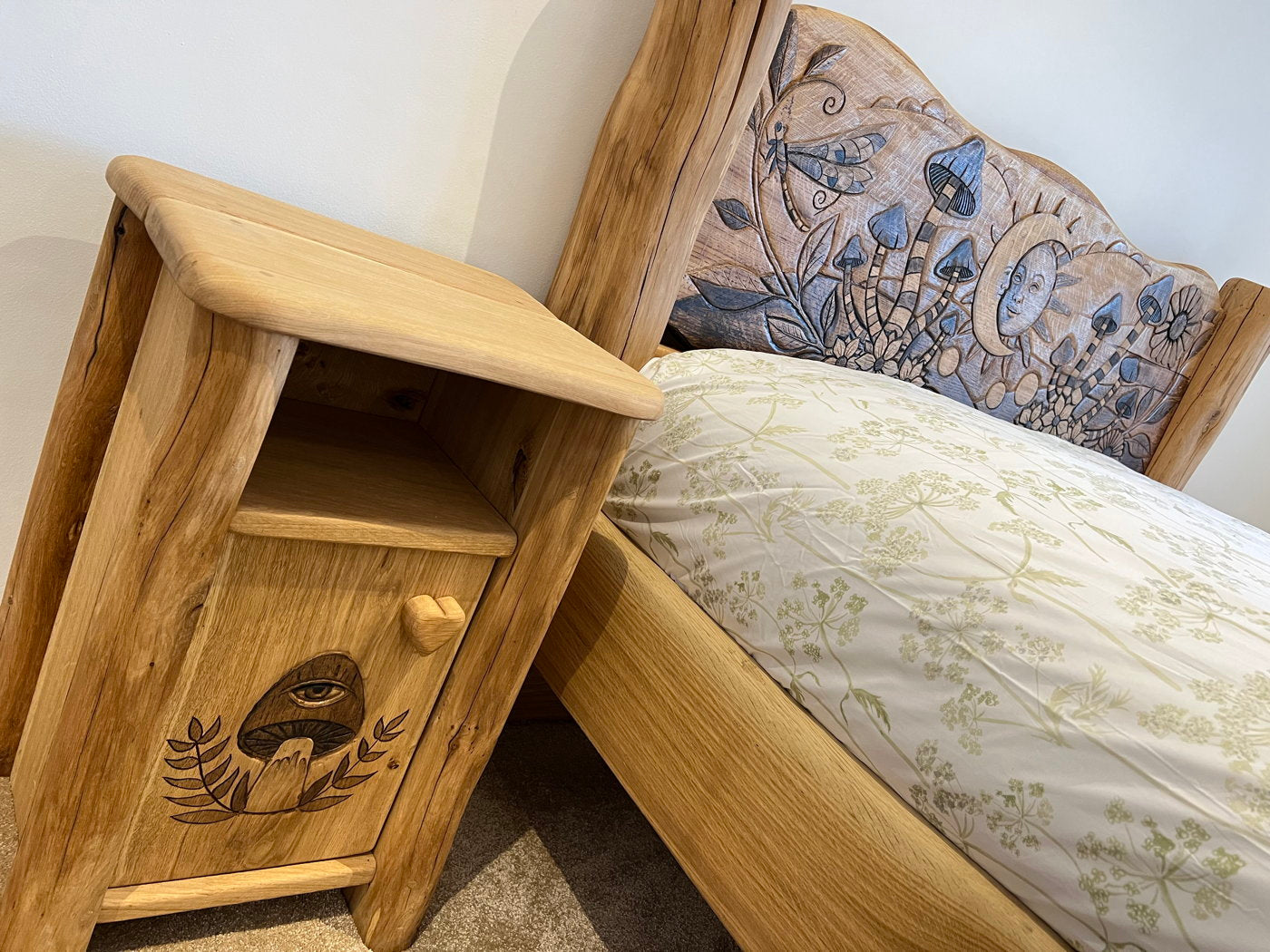 Oak bed and bedside table with carved details