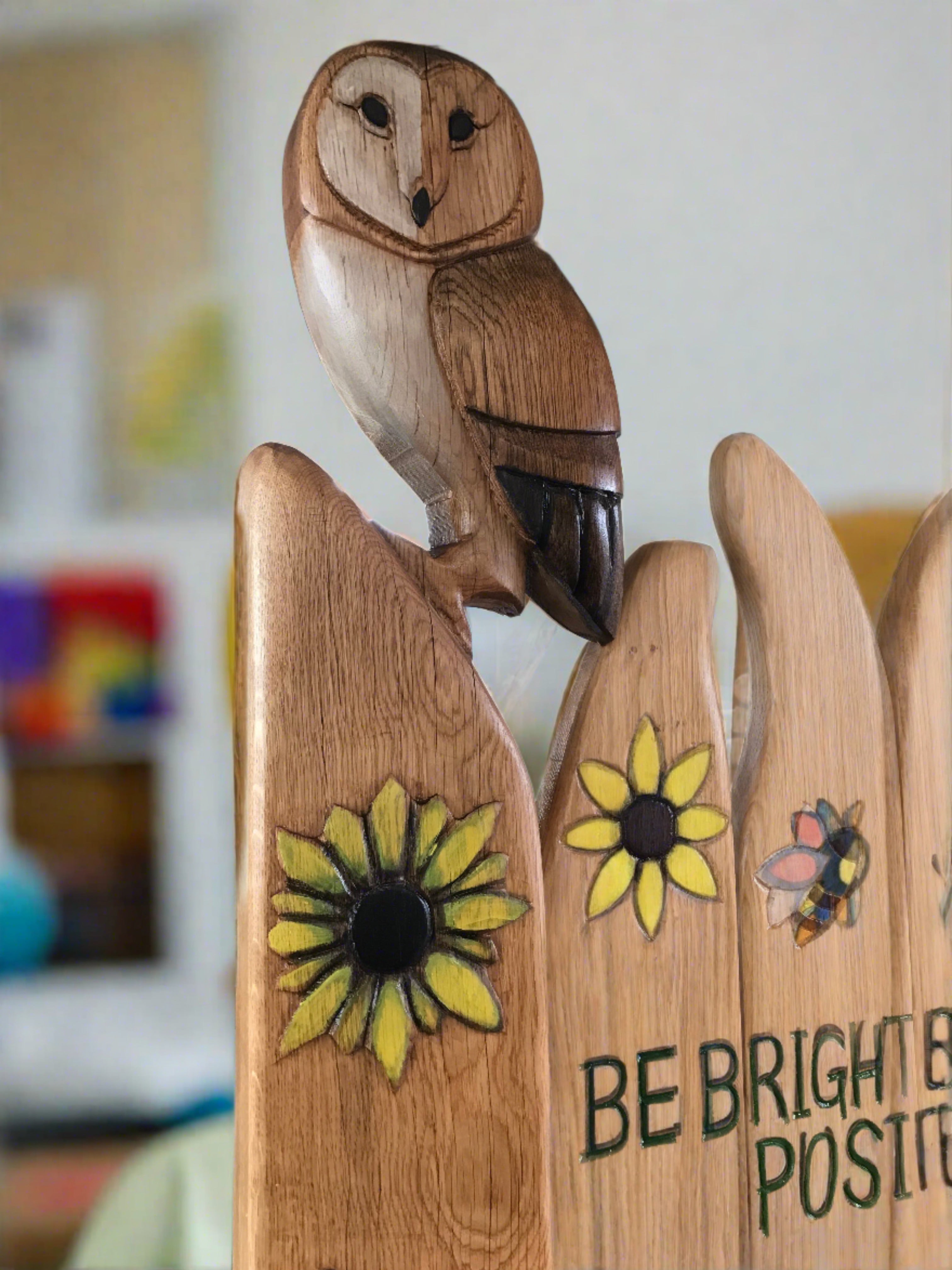 Owl carving on wooden chair with sunflowers