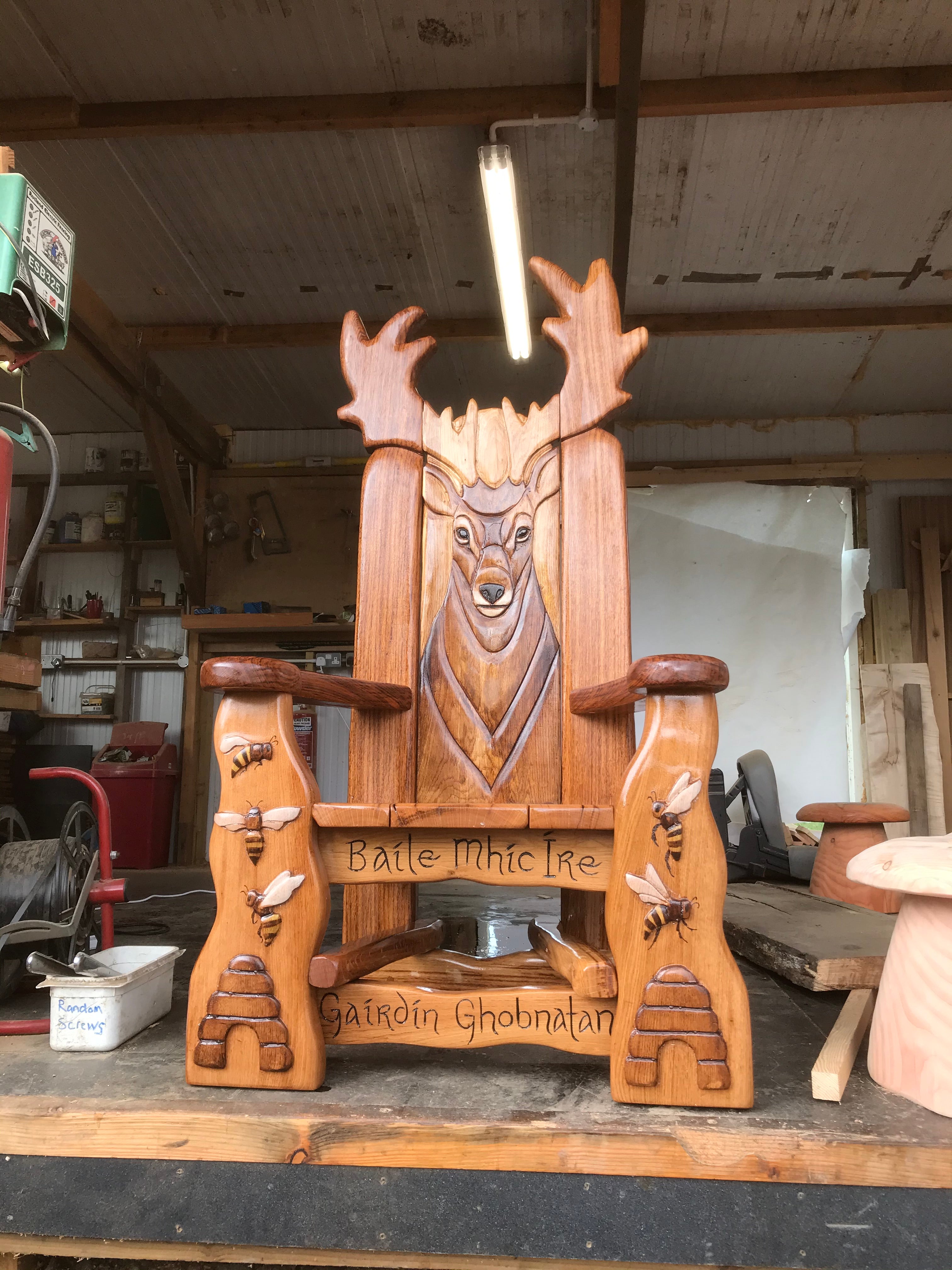 Wooden chair with deer carving in a workshop.