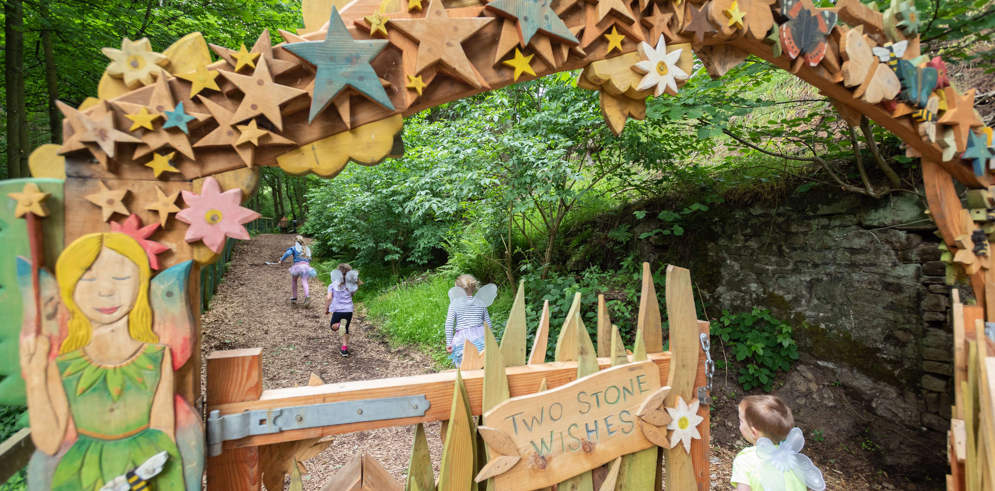 Children running through Studfold Fairy Trail arch