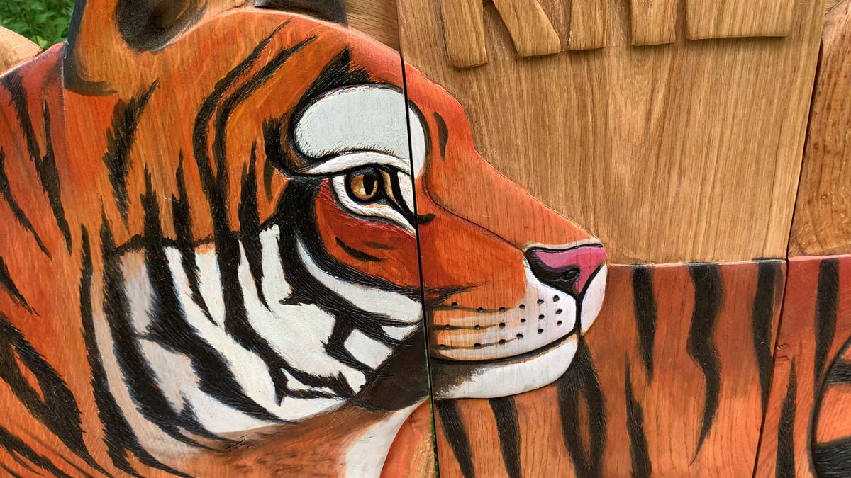 Close-up of tiger carving on wooden bench