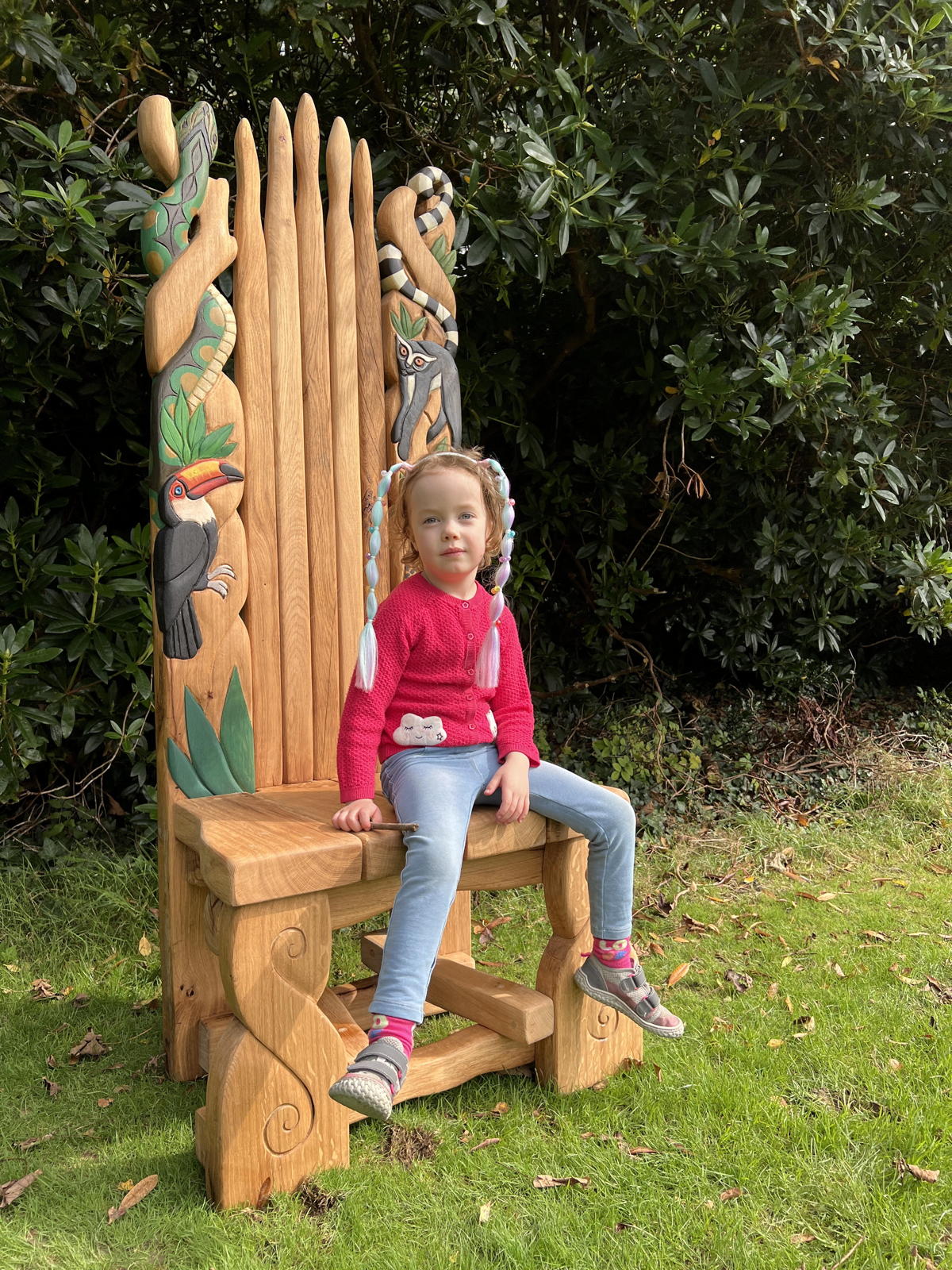 child on Jungle-inspired chair with toucan, jaguar, lemur
