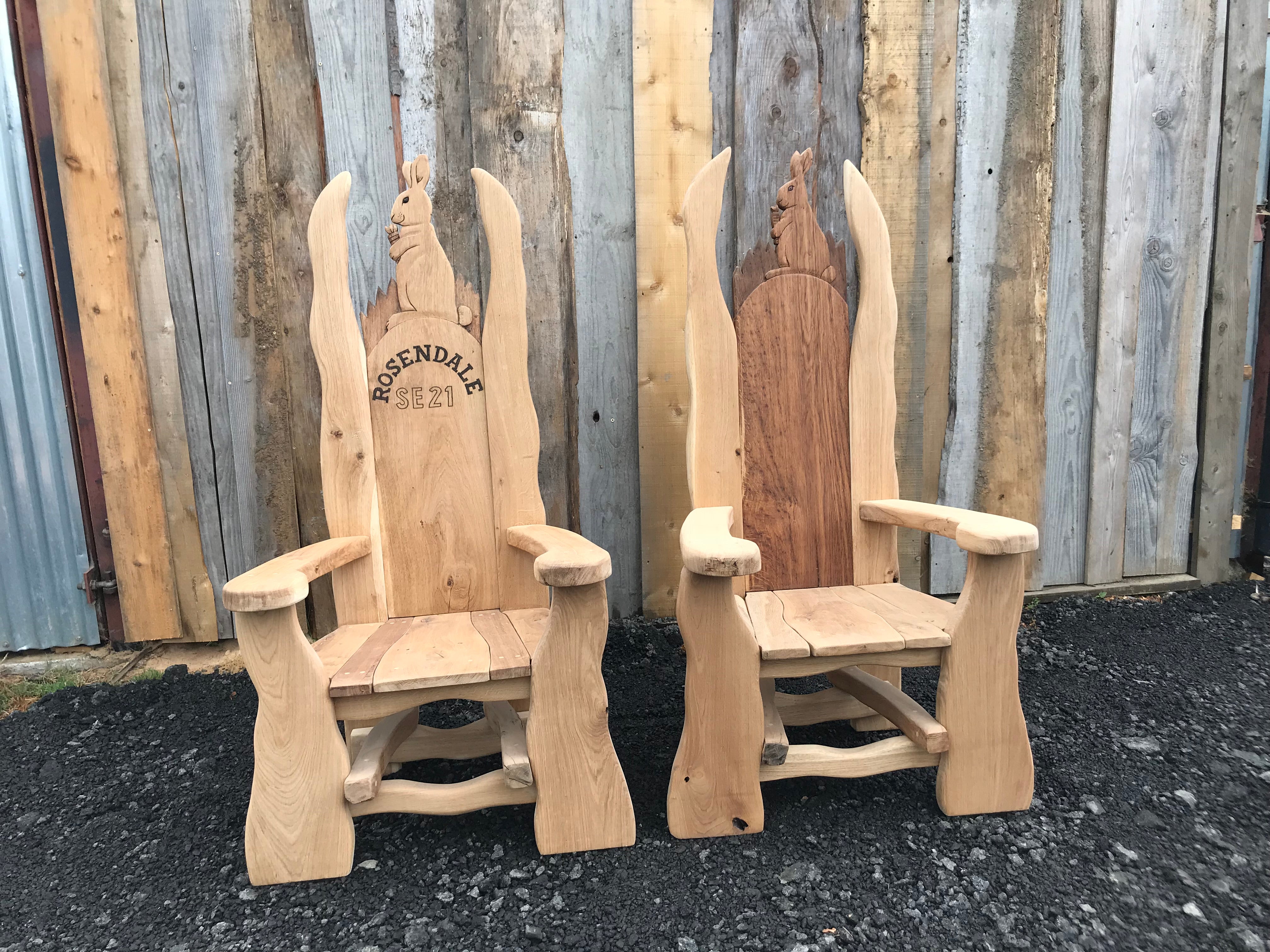 Pair of wooden chairs with rabbit carvings.