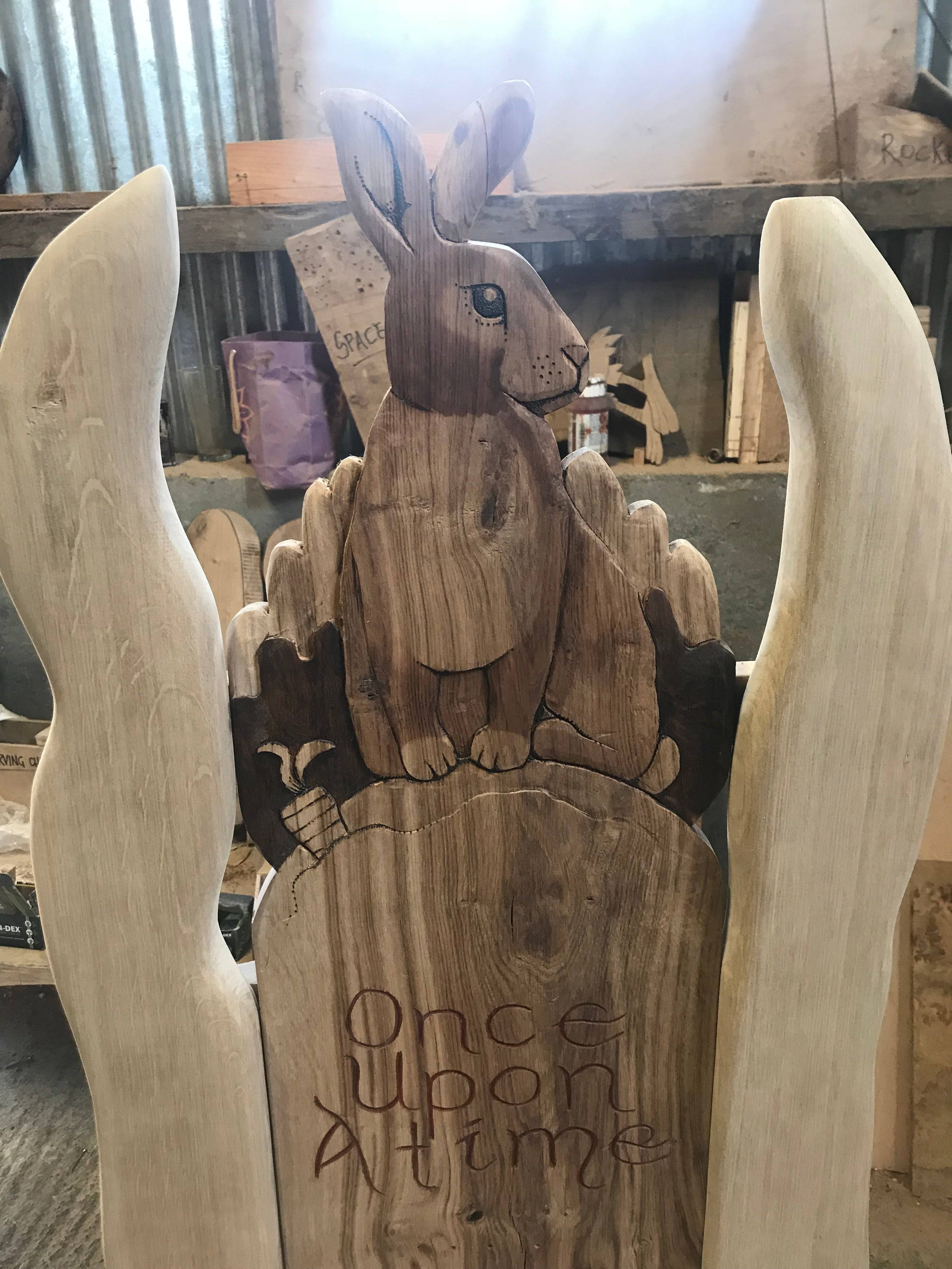 Detailed rabbit carving on oak chair with 'Once Upon A Time'