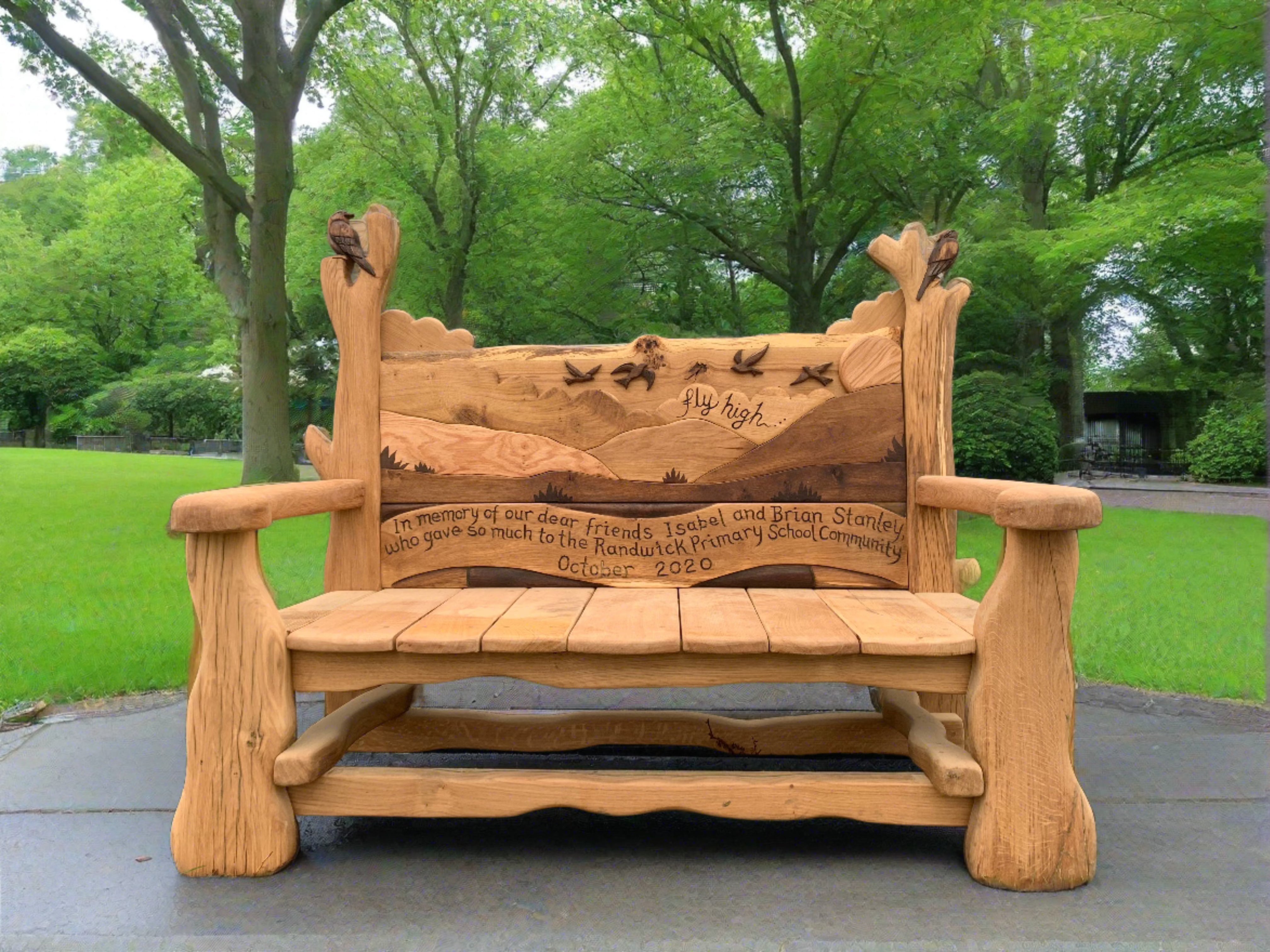 Memorial bench with bird carvings in park