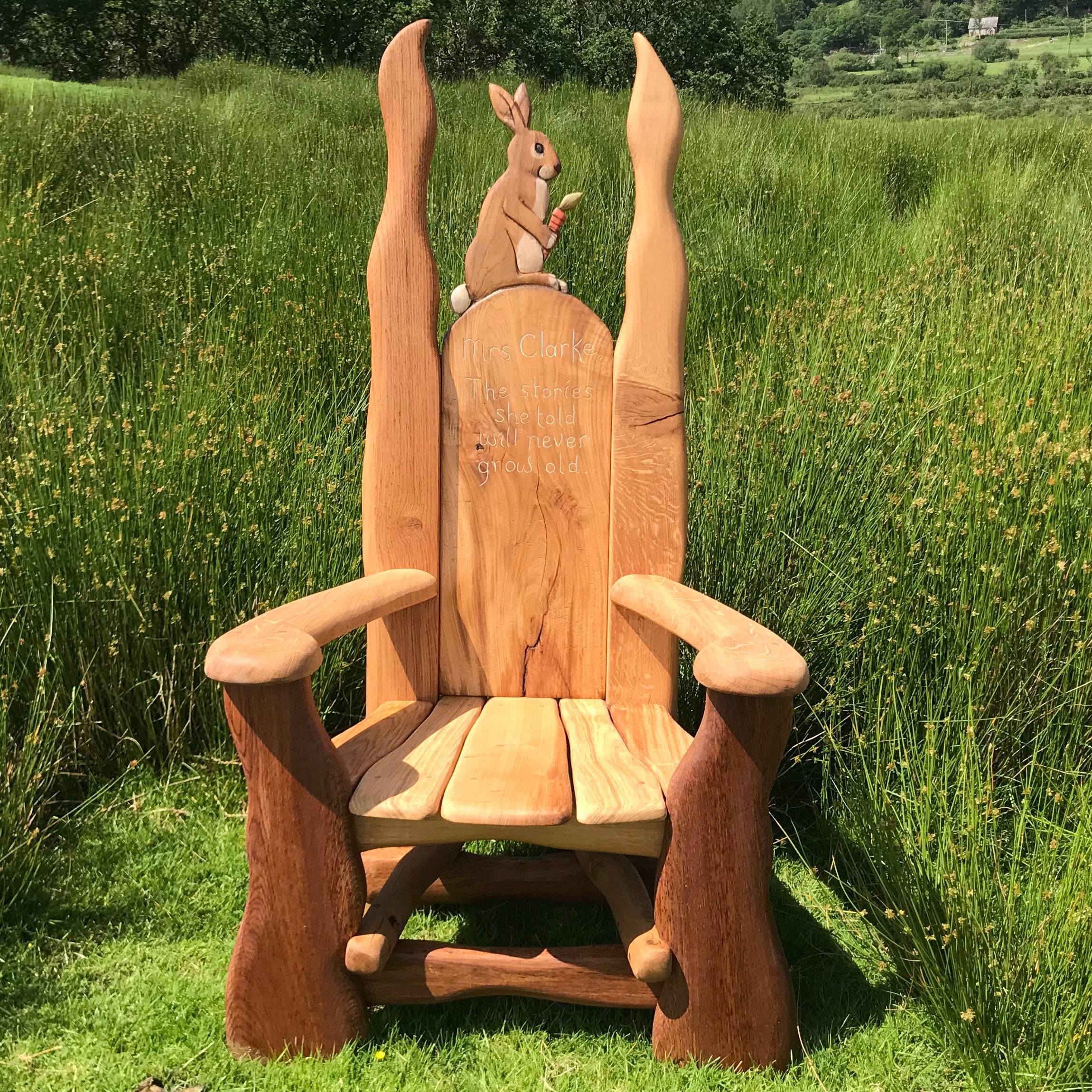 Oak rabbit reading chair in a lush garden setting