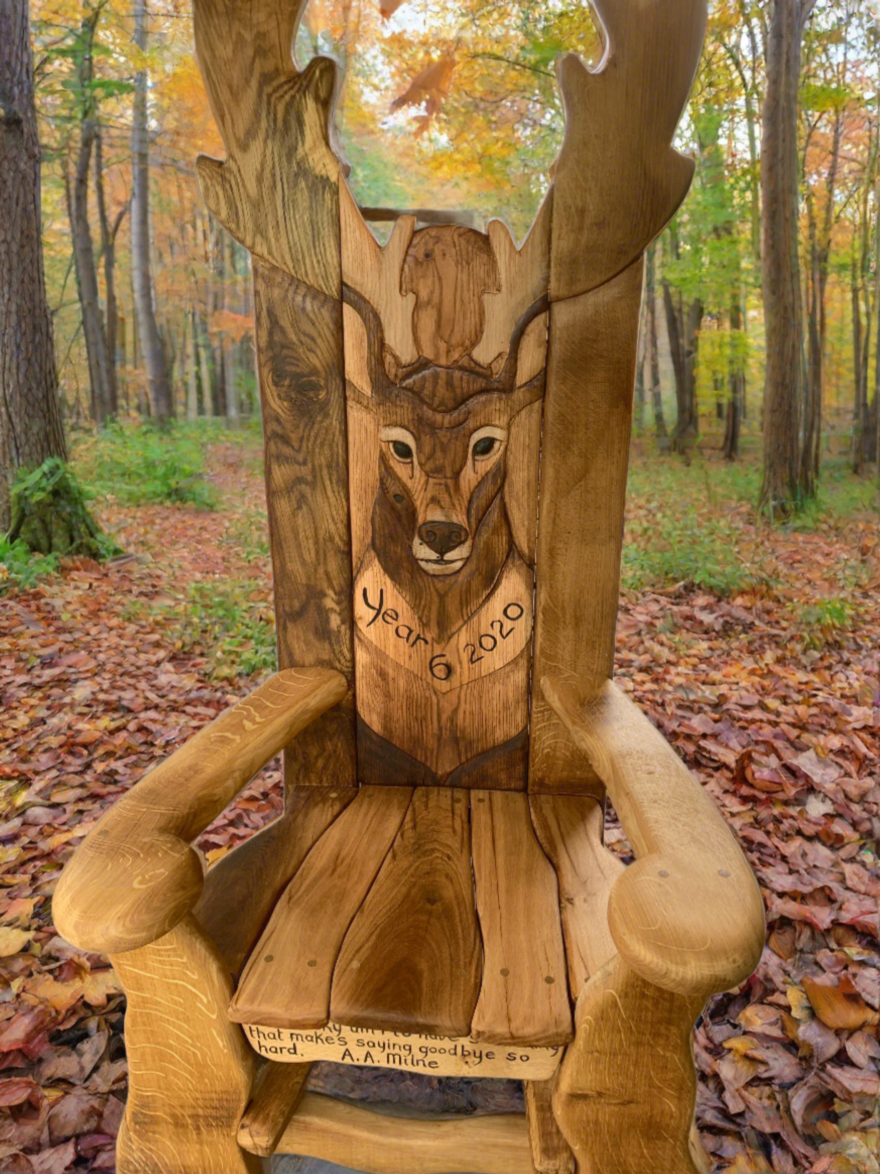 Wooden chair with deer carving in autumn forest.