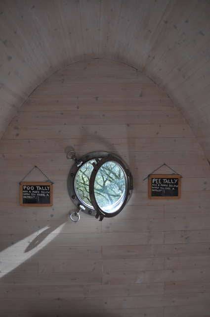 Circular window inside Timber Arc Composting Toilet