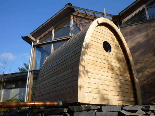 Back view of Timber Arc Composting Toilet near modern building