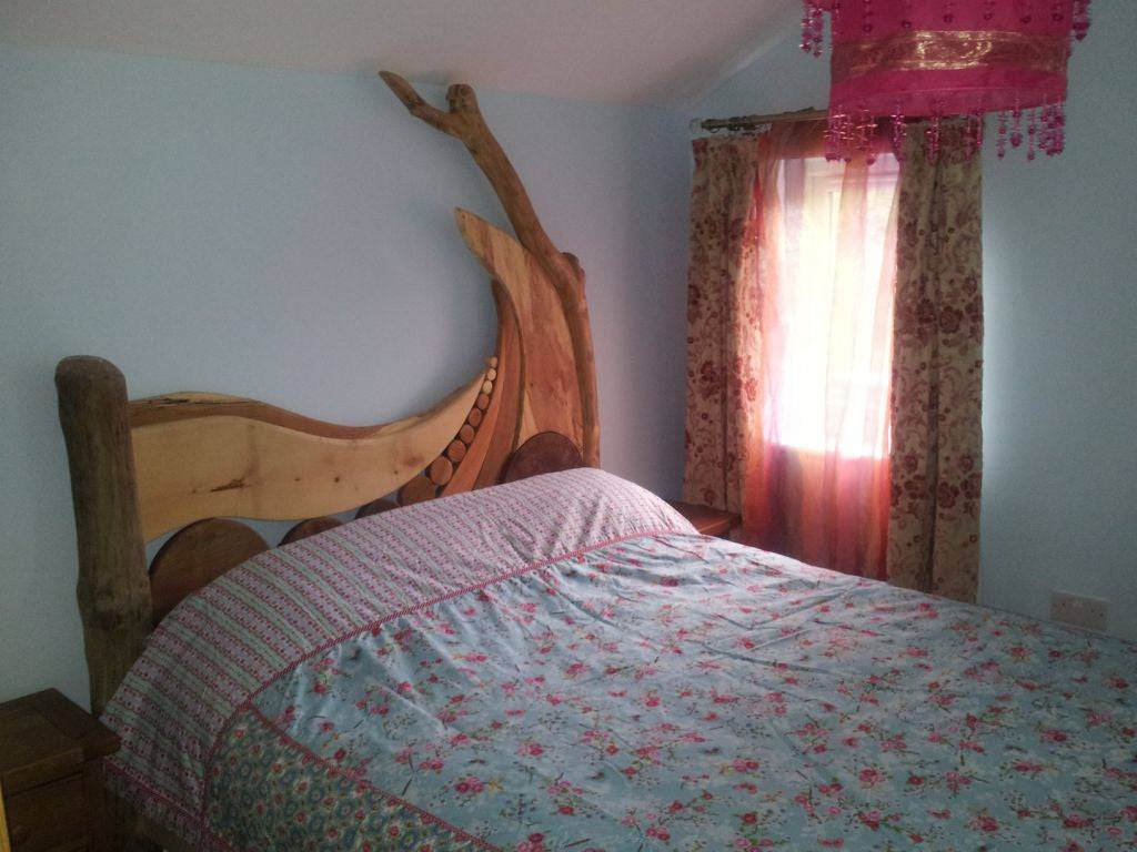 Driftwood bed in cozy bedroom with floral bedding