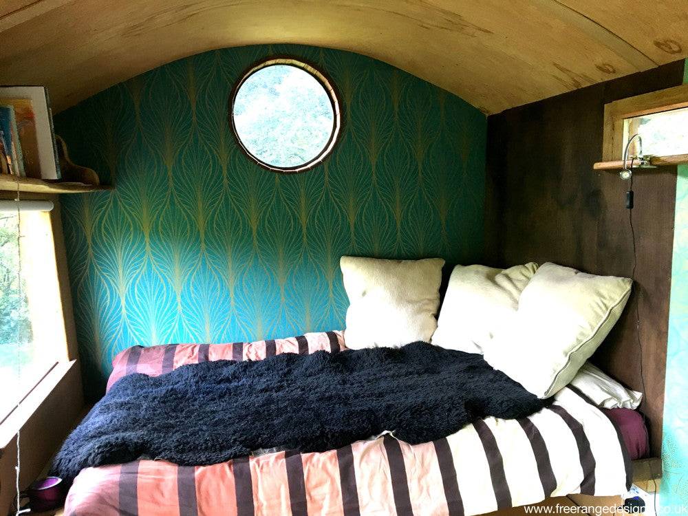 Shepherd's hut interior with bed and round window