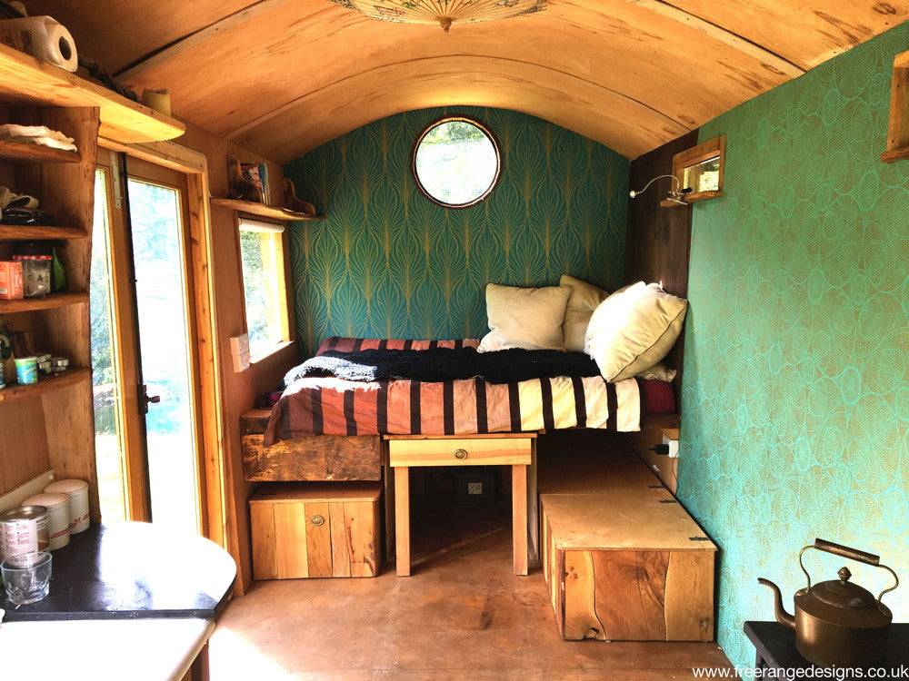 Interior view of shepherd's hut with bed and storage