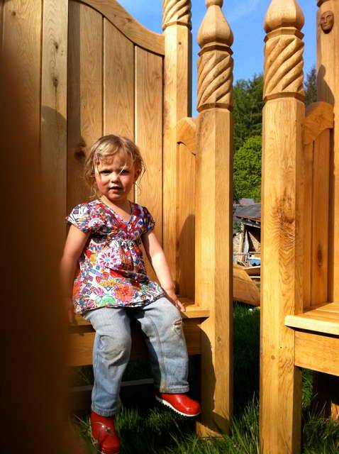 Child sitting on ornate carved storytelling chair