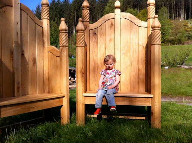 Child seated on storytelling chair in grassy area