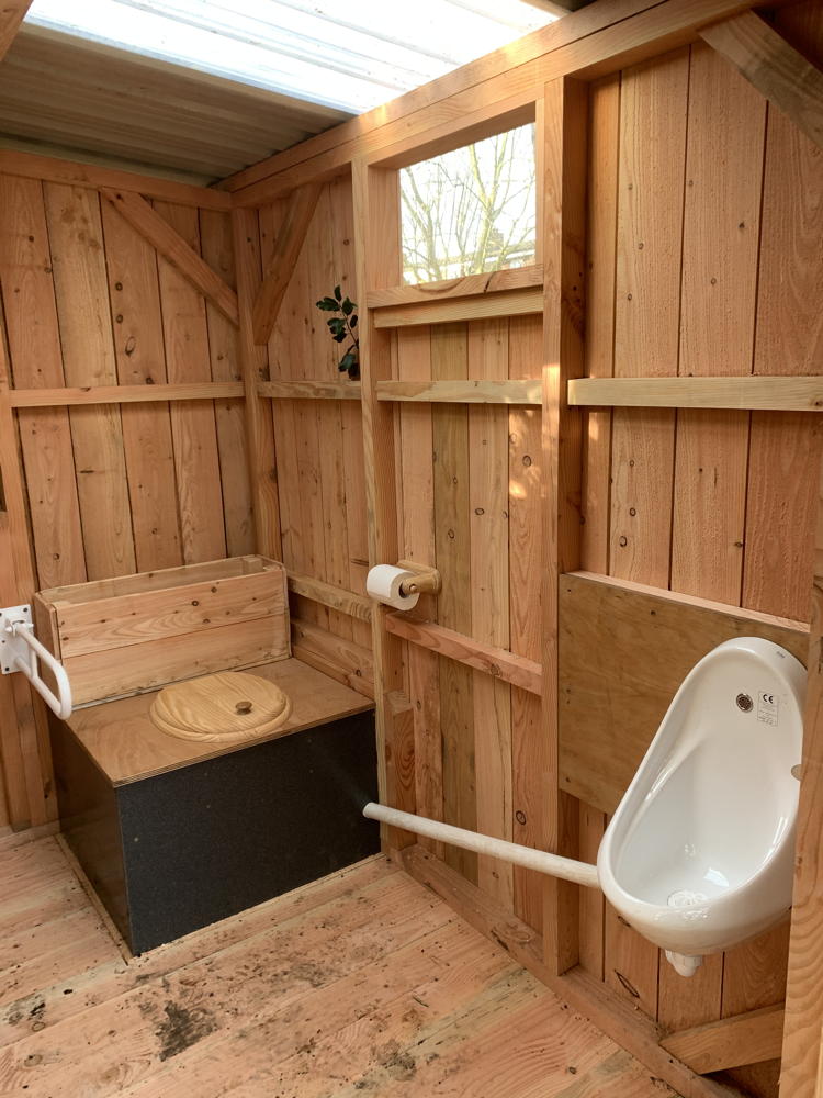 Interior of compost toilet with urinal and seat