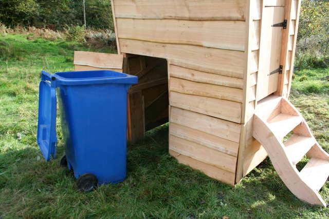 Back view of Gypsy compost toilet with blue bin