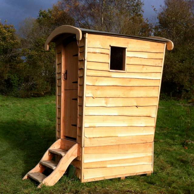 Wooden composting toilet shed in a field