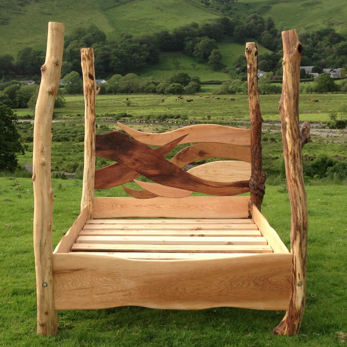 Rustic oak driftwood four-poster bed in scenic landscape