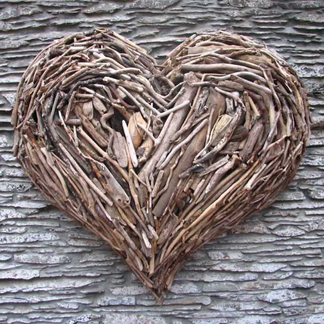 Large driftwood heart wall sculpture on textured background