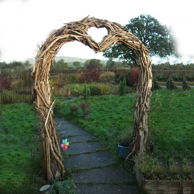 Heart-shaped driftwood arch in garden setting