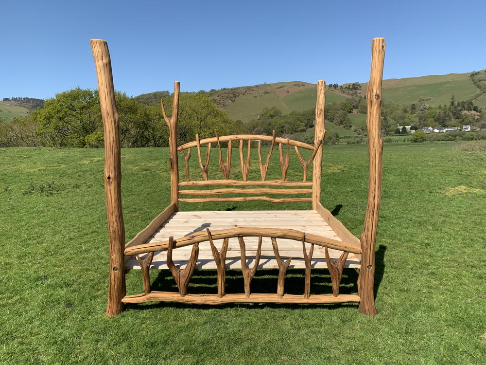 Rustic oak four poster bed in open field