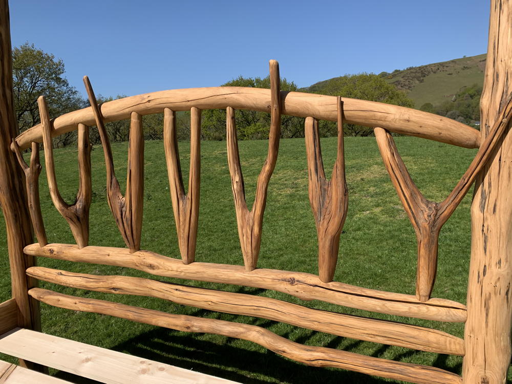 Close-up of oak bed's intricate headboard design