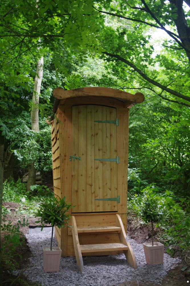 Compost toilet surrounded by greenery