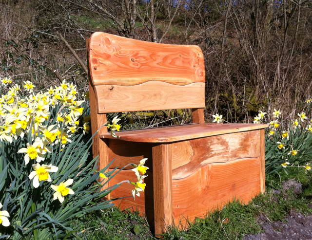 Side view of hand-carved garden storage bench