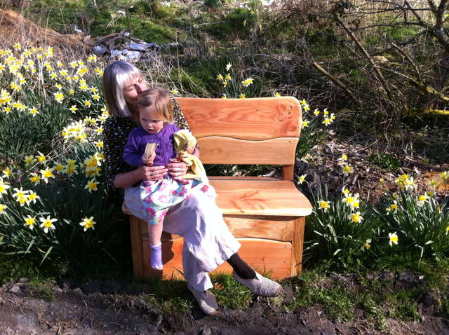 Woman and child sitting on garden storage bench