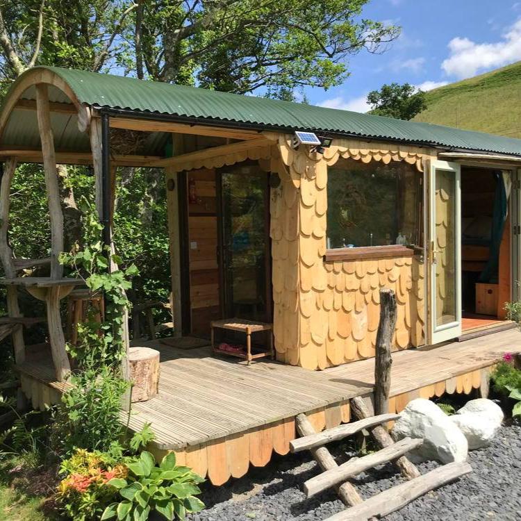 Shepherd's Hut with wooden deck and lush surroundings