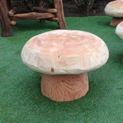 Natural wood mushroom stool on grass