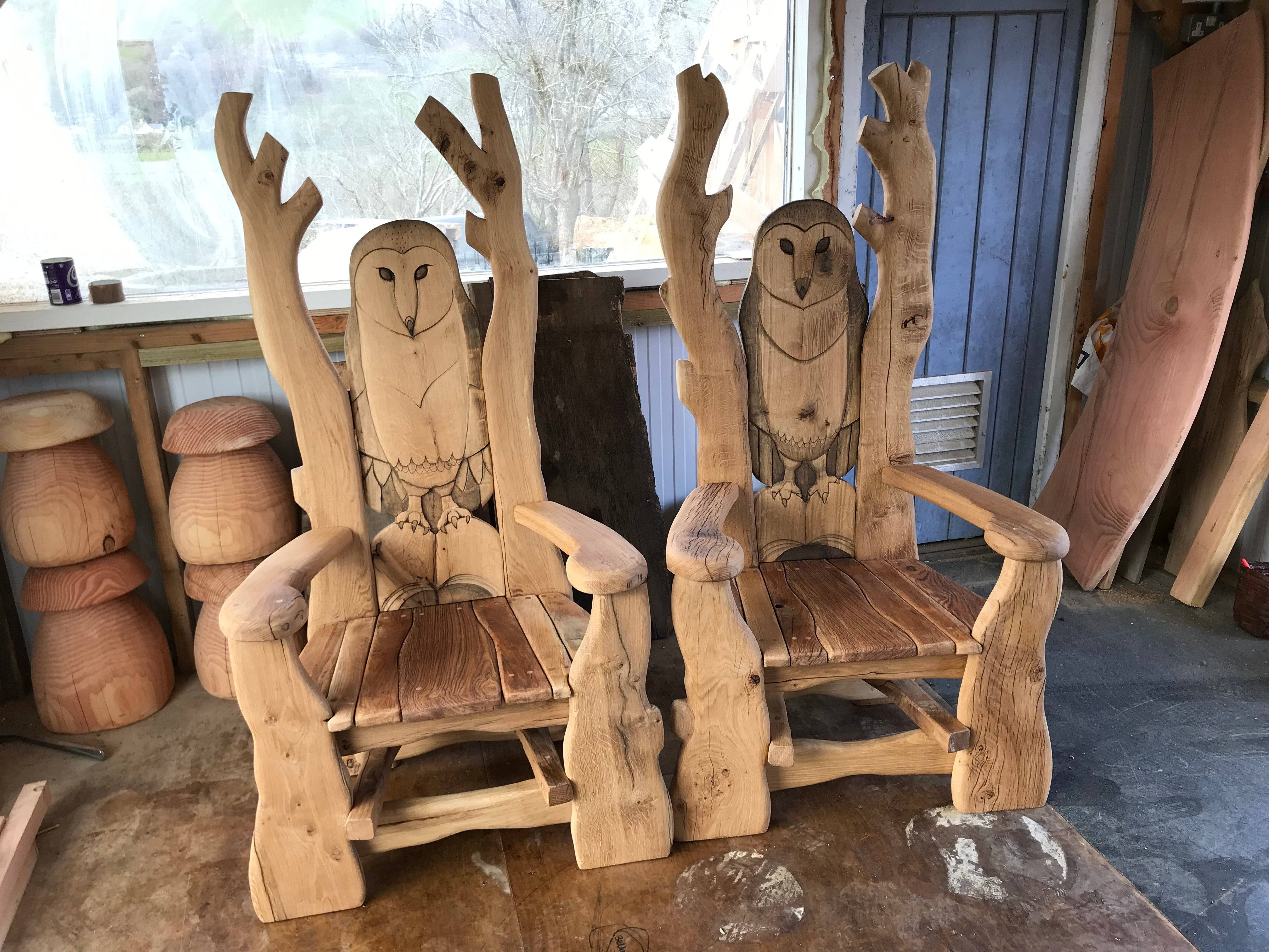 Two carved owl chairs in workshop