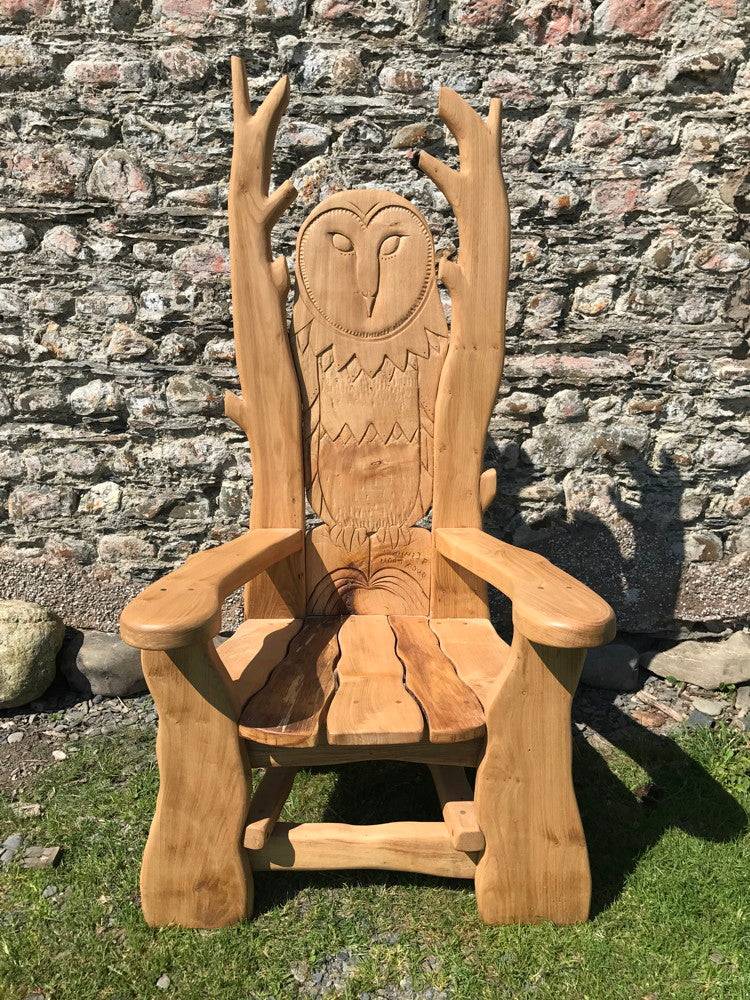 Carved owl chair against stone wall