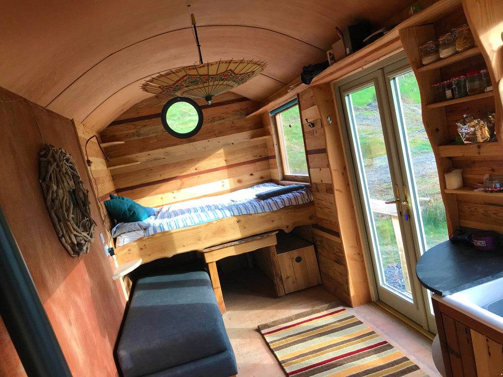 Cozy interior of Shepherd's Hut with bed and seating