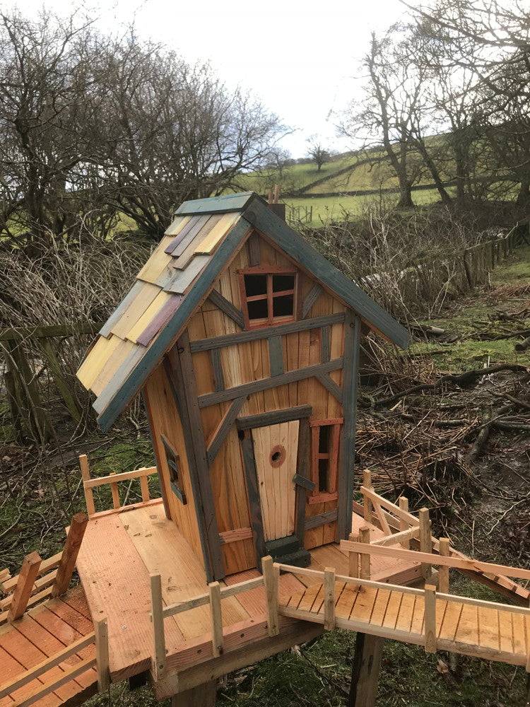 Rustic wooden fairy house with a balcony