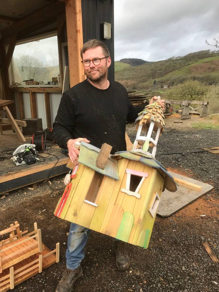 Person holding a colorful fairy house model