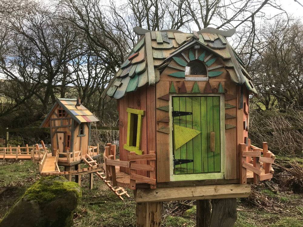 Decorative fairy house with green door and intricate roof