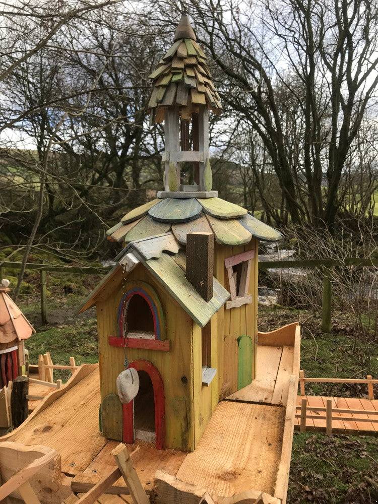 Tall fairy house with a tower and colorful accents